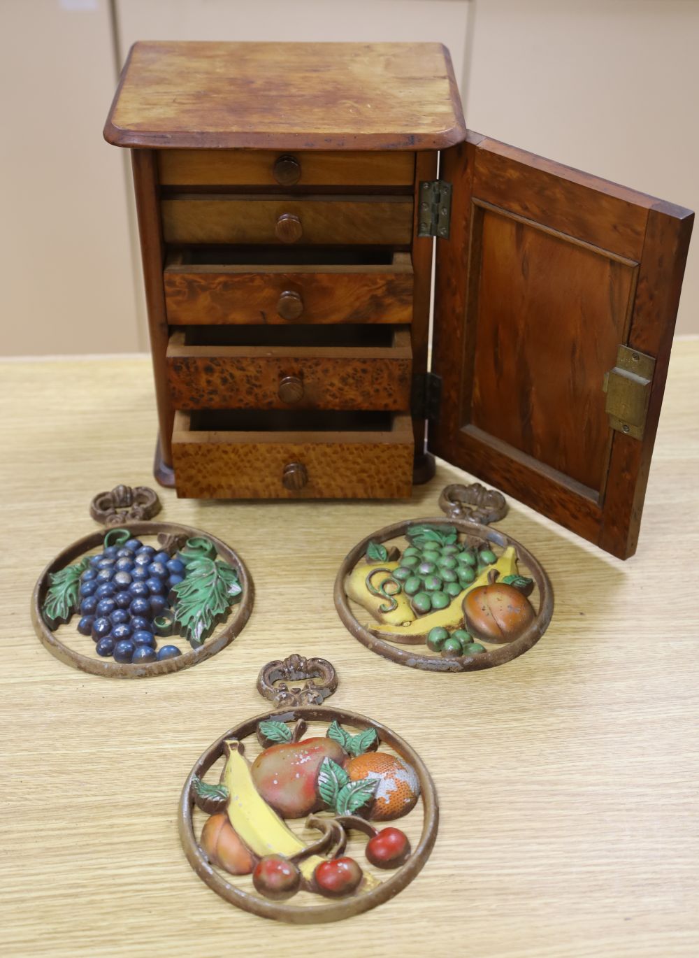 A late Victorian burr yew table-top cupboard, with five enclosed drawer veneered in a variety of timbers, width 22cm, and three cast